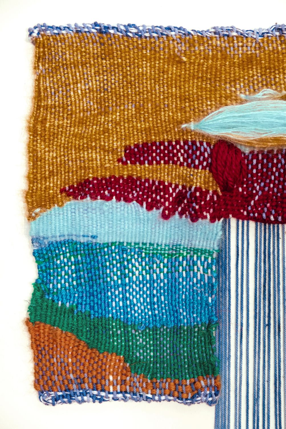 Detail of All For Us to Enjoy: ochre, wine red, turquoise, blue and green woven bands, with blue warp falling free on the right