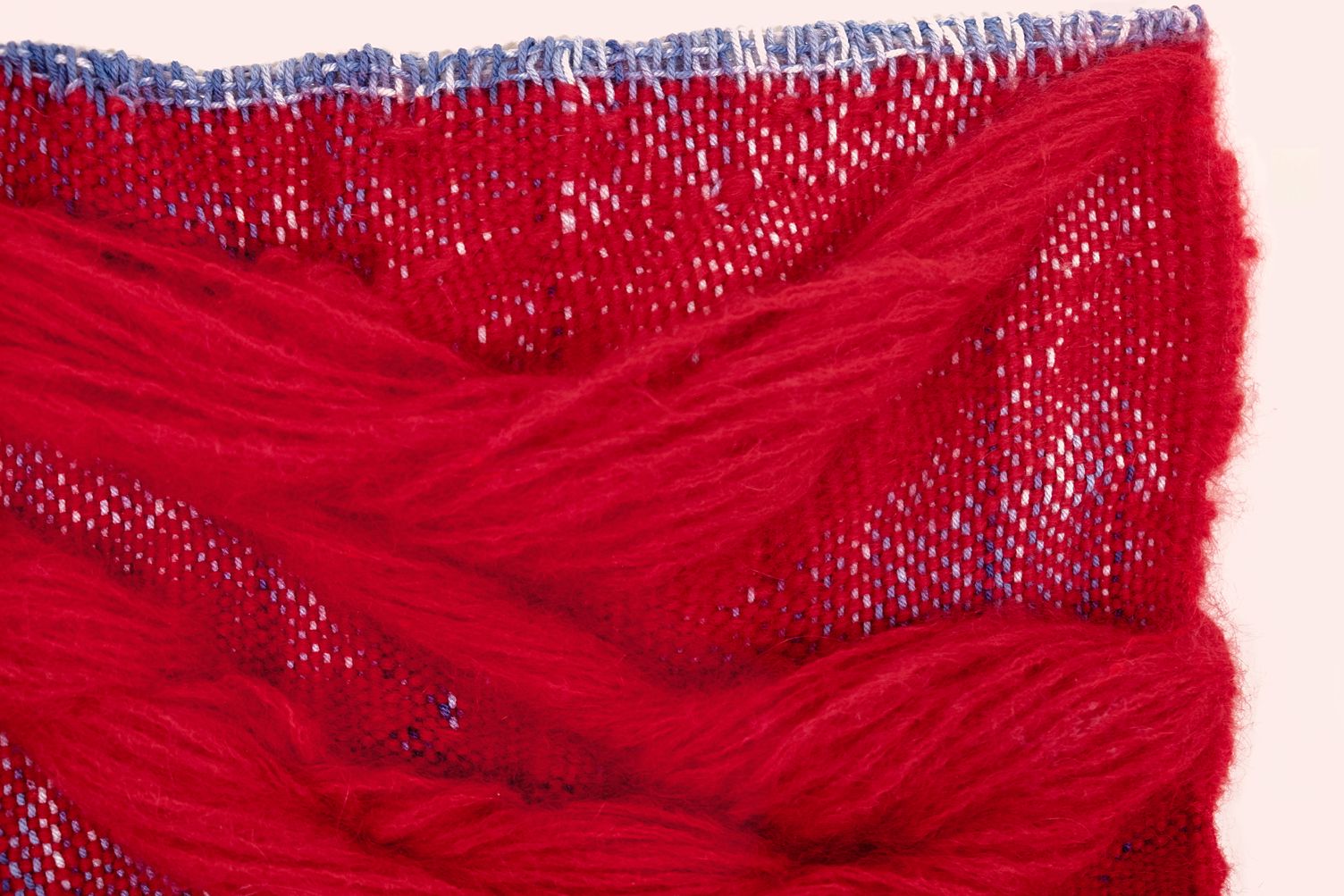 Detail of Love: thick waves of red mohair over red and blue weaving, edged in blue