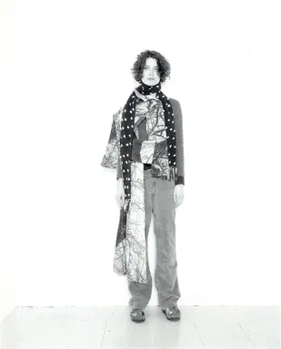 All Events Are Even, page 1: black-and-white photograph of a model alone in a bare-branch-print top, a long polka-dot scarf, and wide grey trousers